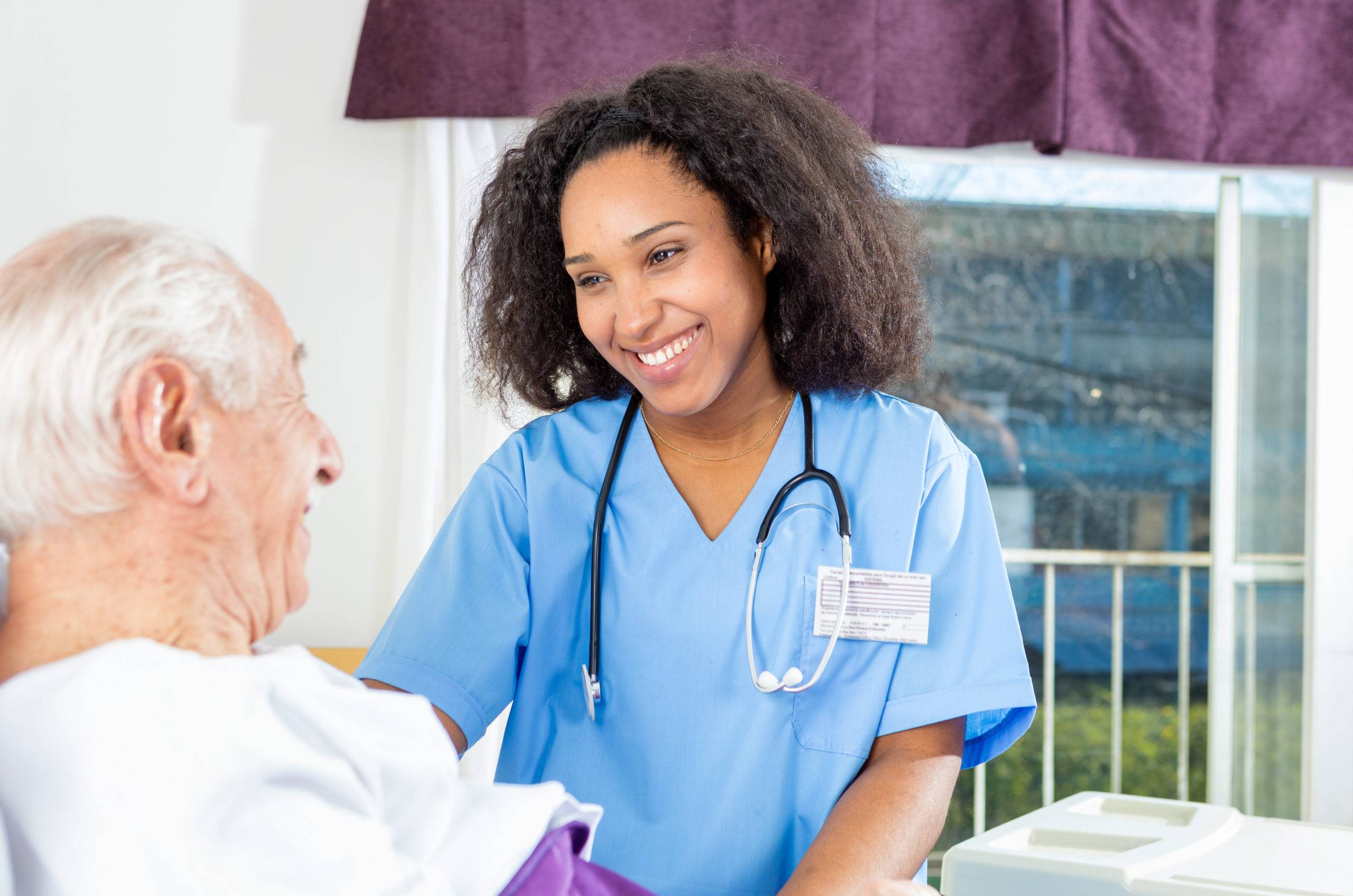 A nurse smiling with an elderly man