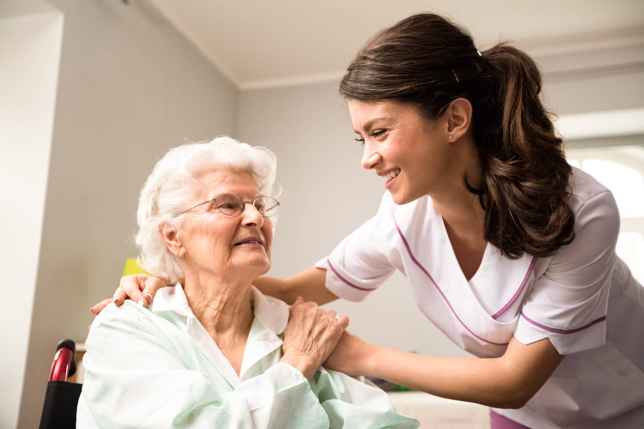 a caregiver comforting an elderly woman