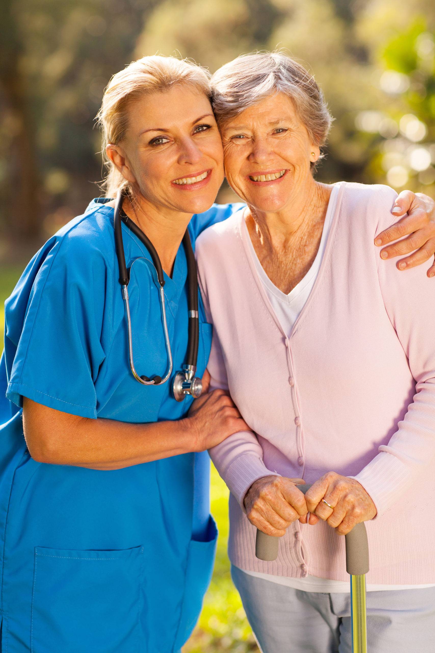 A nurse hugging a smiling senior woman